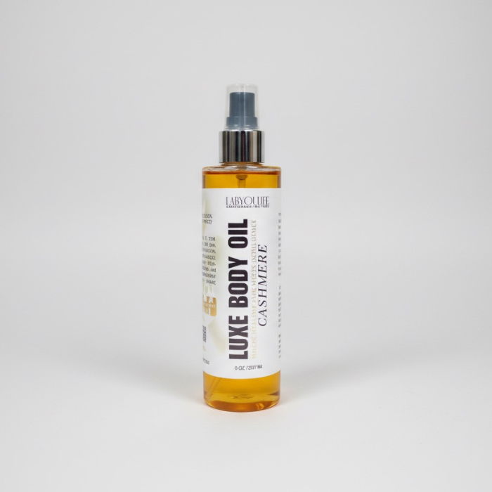 Bottle of Luxe Body Oil with a white label on a light gray background