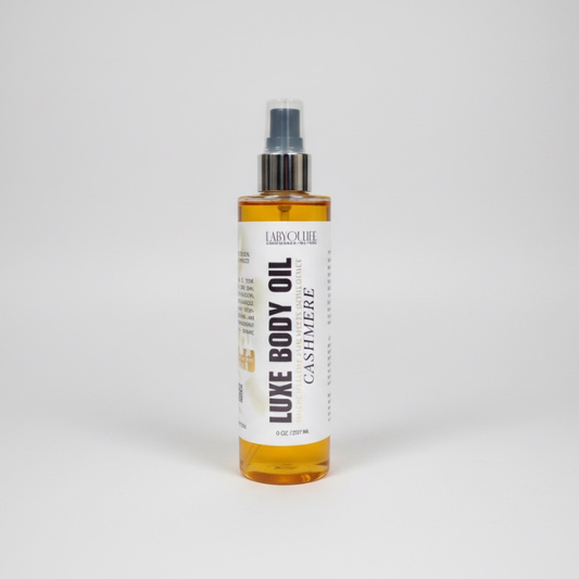 Bottle of Luxe Body Oil with a white label on a light gray background