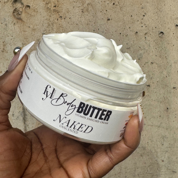 Hand holding a jar of fabyoulife Body Butter Naked against a concrete background